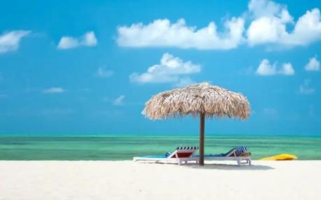 Two sundecks and a shed on a white sand beach 