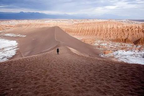 man walking on desert sand