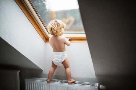 a small child climbing on a radiator