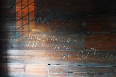 Graffiti on wood including 'HR, JH, Painters 1824' in flowing script.