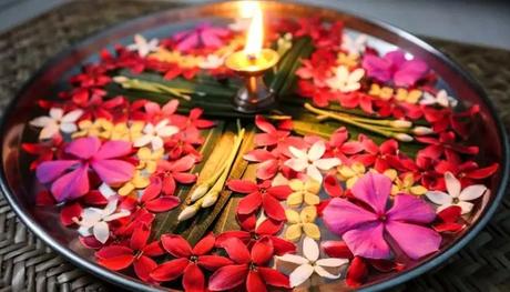 A picture of aarti thali with fresh flowers and ghee lamp that you can find in temples which are among the places to visit in and around Silchar.