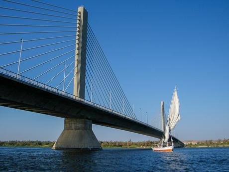 felucca-boat-sailing-under-a-bridge-on-the-nile-river