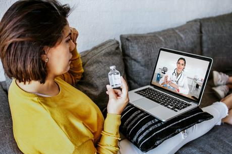 Une patiente latine assise sur un canapé à la maison a un appel vidéo avec une femme médecin en ligne en Amérique latine