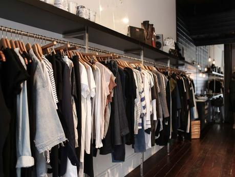 clothes hanging on a rack in a boutique shop