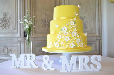 Yellow wedding cake with  white Mr and Mrs centerpiece