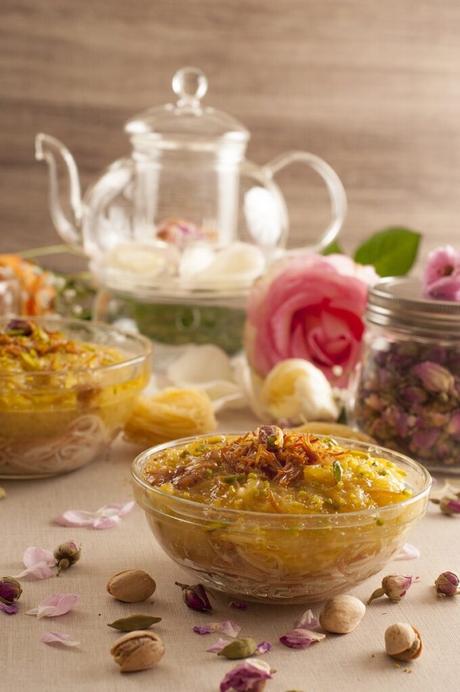 traditional omani food and roses next to a glass tea pot