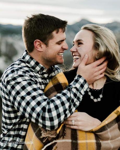 winter engagement photos couple with blanket looking on each other