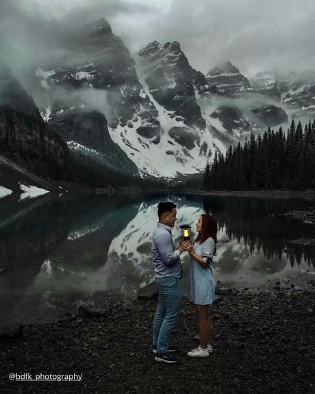 winter engagement photos couple at winter holding lantern and scape holding