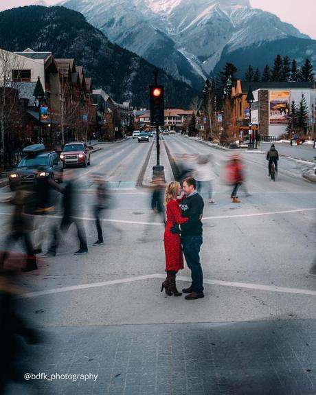 winter engagement photos couple hugging near snowy mountains