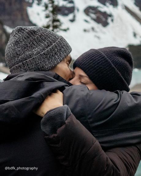 winter engagement photos couple in caps is hugging