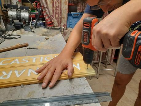 Splitting the wooden sign into two halves: drilling the holes for the cord