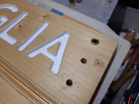 Splitting the wooden sign into two halves: adding metal eyelets to the holes for the cord