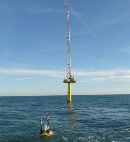 Metocean buoy in front of met-mast in the North Sea.