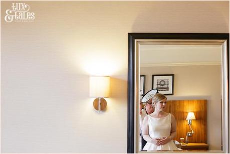 Bride looks in mirror at Cedar Court Grand Hotel Wedding