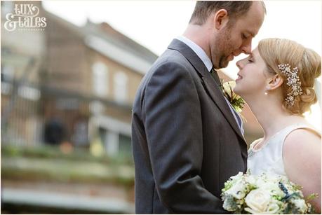 Bride and groom cuddle in low winter light at York winter Christmas wedding