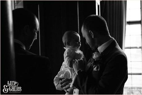 Groom holds baby at York wedding