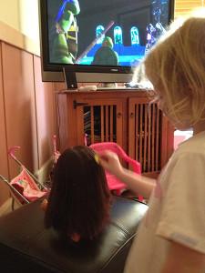 Making sure Dora's hair is brushed, while watching the Teenage Mutant Ninja Turtles