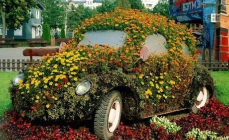 Green Volkswagen Beetle Covered in Flowers