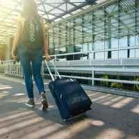 Traveler with roller bag, outside airport