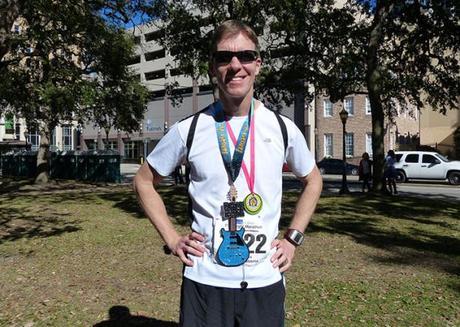 Mike Sohaskey sporting medals from 2014 Mississippi Blues & First Light marathons