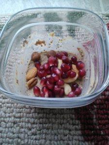 Protein chia pudding topped with pom seeds and raw mixed nuts. 