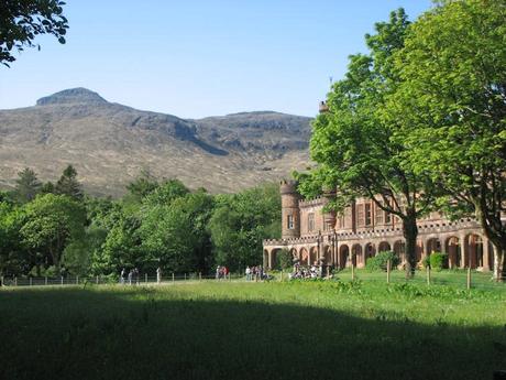 rugged Scottish landscape, grand building on the left with green trees