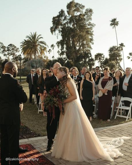 documentary style wedding photography dad kisses the bride at the wedding