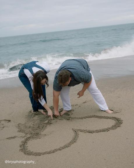 36 questions that lead to love a man with a woman drawing a heart on the sand