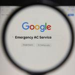 a magnifying glass on a screen showing a Google search for emergency AC services