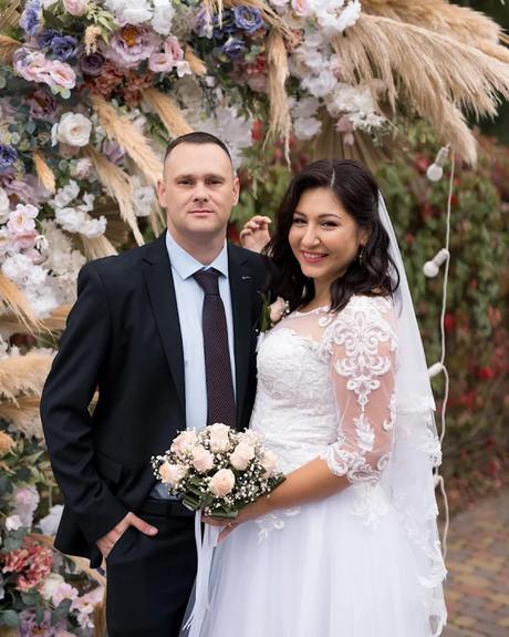 wedding forward chiefs editor real wedding bride and groom posing in front of the wedding arch