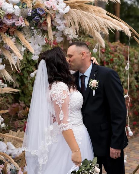 wedding forward chiefs editor real wedding bride and groom kissing in front of wedding arch