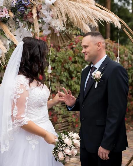 wedding forward chiefs editor real wedding bride and groom exchanging rings in front of wedding arch