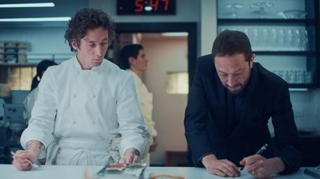Jeremy Allen White wears a white chef’s coat while standing next to Ebon Moss-Bachrach in The Bear 