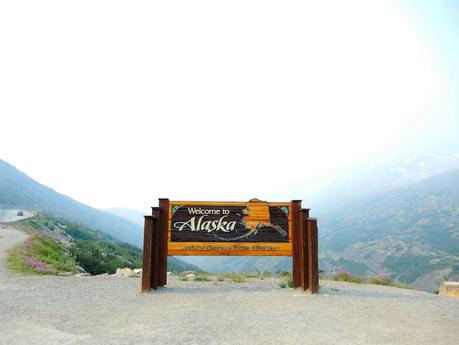 Alaska brown wooden signage on gray sand during daytime