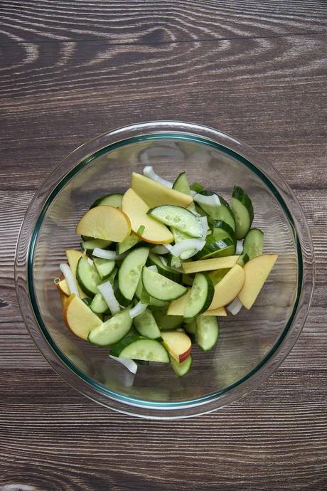 bowl with mixed cucumbers and apples for making a Korean cucumber salad