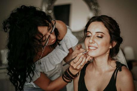 Cosmetology Beautician Putting Make Up on a Customer Face