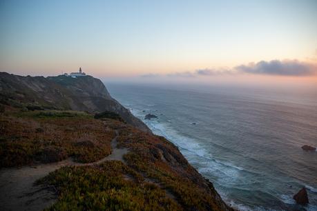 Cabo da Roca headland and lighthouse with a moody sea beyond at sunset in Sintra Cascais national park