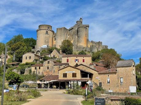 Chateau de Bonaguil castle rising dramatically above a traditional rural French hamlet