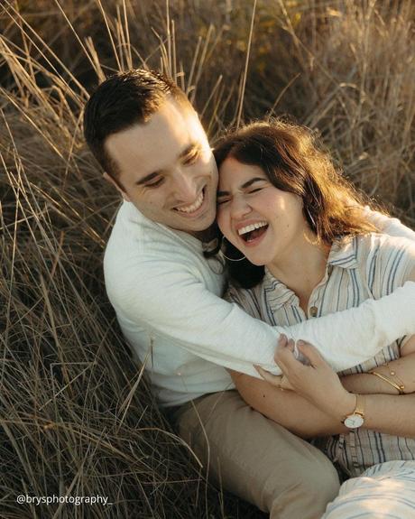 engagement photo captions laughing couple on the dry grass