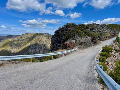 Windy mountain road passing over Estrada do Portal do Inferno pass with more mountains in the distance