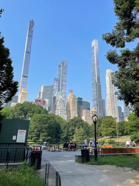 New skyscrapers just south of central park as seen from the park with a picnic area in the foreground