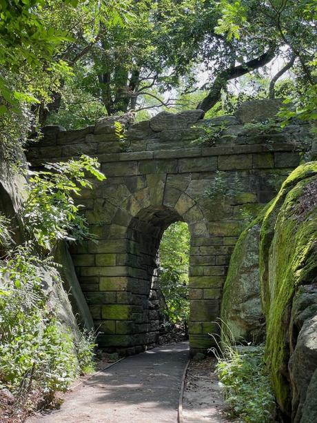 Stone arch surrounded by lush greenery in the Ramble in Central Park