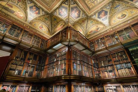 Interior of the Morgan Library & Museum with old books, elaborate vaulted ceilings, and lots of dark wood