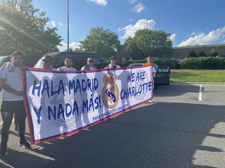 The local Real Madrid fan club holds a banner as they await the team’s training session in southeast Charlotte.