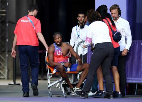 Bronze medalist Noah Lyles of Team United States is taken off from the track in a wheelchair after competing in the men's 200m final at Stade de France. Later he told reporters he tested positive for COVID days before this race.