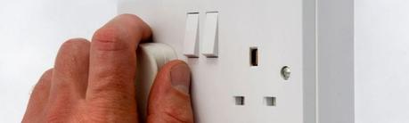 hand unplugging a uk plug