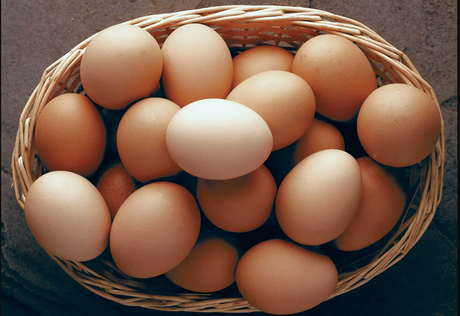 A basket of eggs of mixed colours from white to brown lying on the table