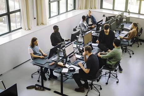 a group of male and female programmers working in an office