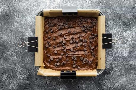 Avocado Brownies, batter pressed into 8x8 pan, with extra chocolate chips added to top