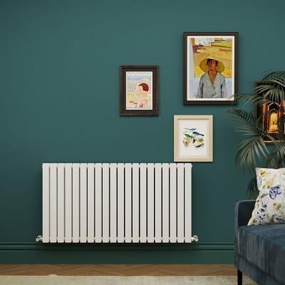 A white Milano Capri horizontal designer radiator on a green sitting room wall